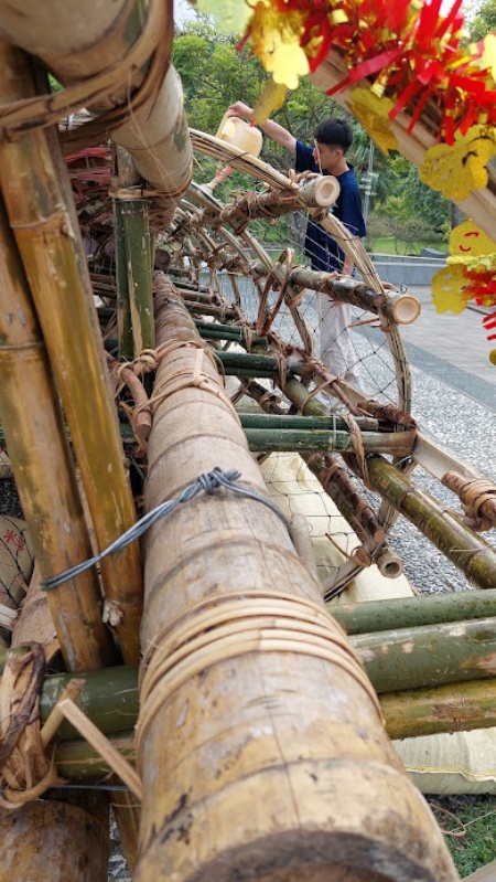 工讀生幫飯棧澆水，防止竹材及藤皮收縮產生空隙導致棧體結構鬆脫。