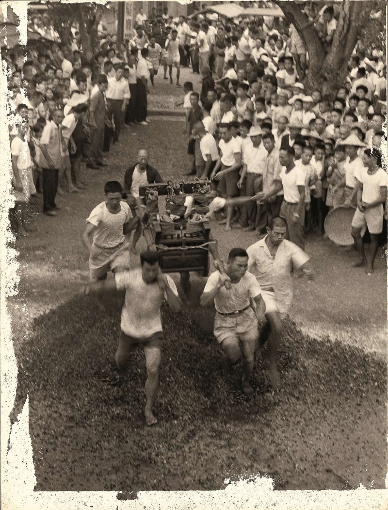 五位信眾扛著神轎一起奔跑過悶燒的木炭火堆。