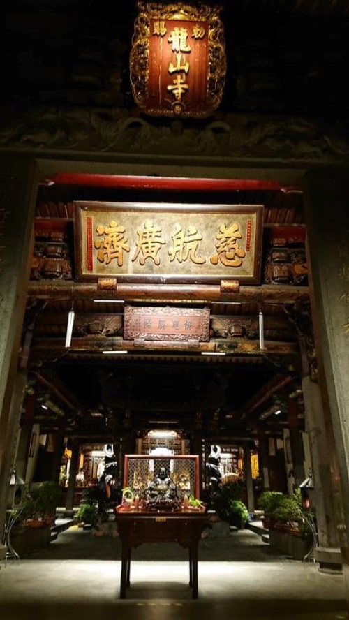 圖23：淡水龍山寺現景，廟內許多燈具角度皆經過設計， 如「慈航廣濟」匾以及龍山寺廟匾。（來源：洪靖翔 攝）