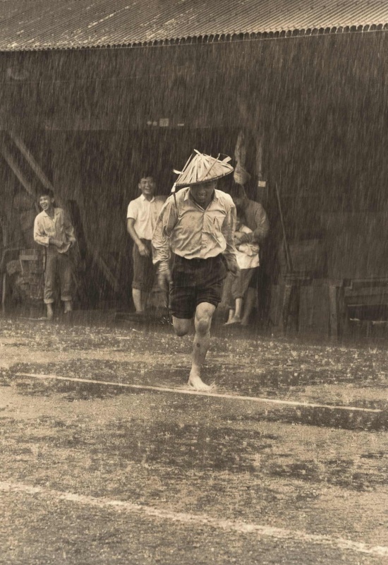 圖4：林永懋先生的哥哥在雨中戴斗笠奔跑。