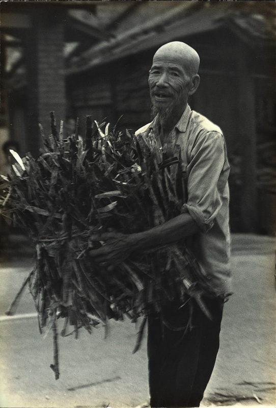 圖7：一位抱著甘蔗皮的老先生穿過馬路。