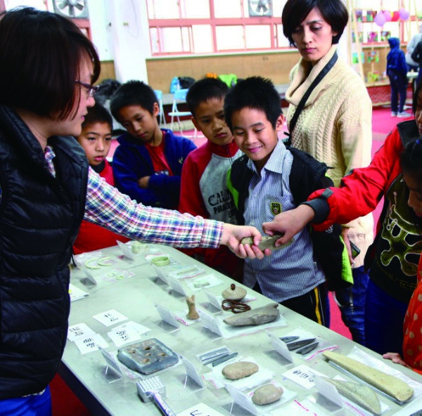 博物館的環教老師正在引導同學觀察接觸史前文物標本