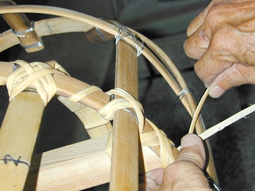 鐵絲容易割傷扛抬大神尪者，這道綁籐的程序主要是保護使用者避免被鐵絲割傷。使用的籐條需先浸過水，方能比較柔軟、容易綁，且不易斷裂。
