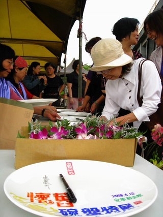 報到台讓來賓於盤子上簽下姓名，以紀念懷舊碗盤特展(林正芳提供)