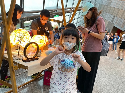 小朋友高興的拿著自己動手做的浮球彩繪作品