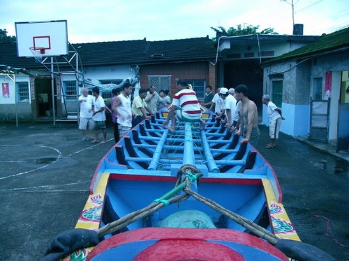 大伙將整理好的龍舟扛出安置