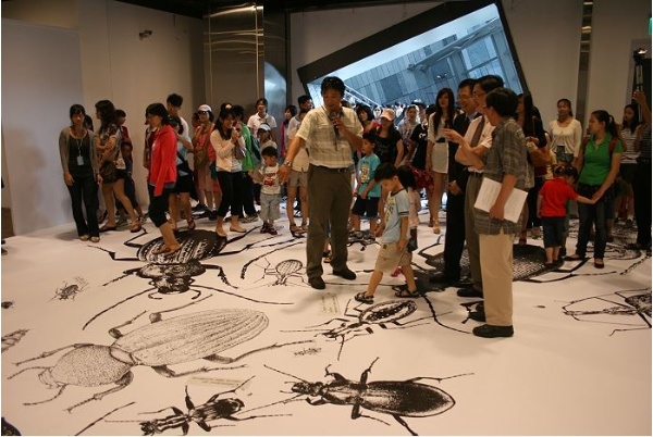 宜蘭大學的毛俊傑教授正在解說入口大型平面卻有立體效果的蟲蟲插畫，讓你在蟲蟲的迎接下進入步行蟲的天地