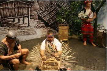 宜蘭縣原住民部落大學伊娜舞蹈班的表演者在泰雅家屋前示範藤編