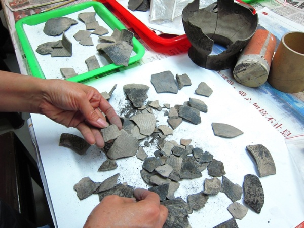 把一個個小小的碎片放在桌子上，找找有沒有可以和相互黏合的陶片