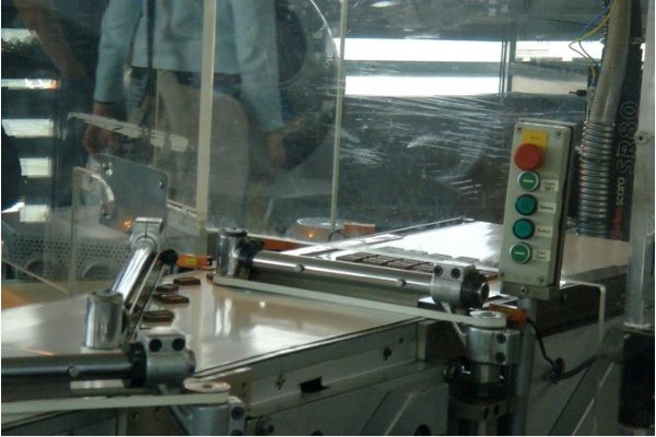 巧克力生產線：(2)成型的巧克力塊通過上圖的機器品管，便可直接包裝成市售商品。整條生產線隔著透明的壓克力玻璃，呈現在遊客面前。