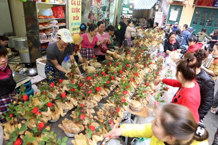 越南過年祭祀時雞隻嘴上插玫瑰的特殊景象。