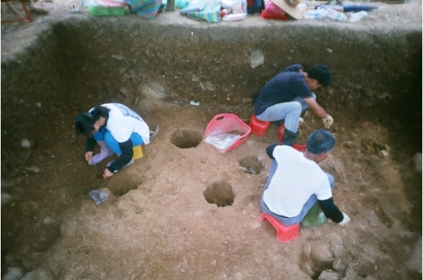 發掘團隊於土坑中工作和時間賽跑著。摘自《丸山遺址》，蘭陽博物館2012年7月份電子報。