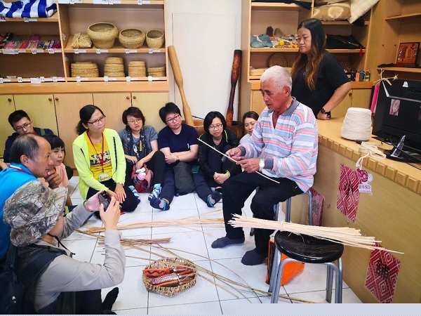 大家在協會裡席地而坐聽卓順來爺爺耐心教導藤編