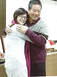 社區工作人員披上李後進送的圍巾，並和他擁抱。