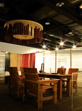 手創蘭陽展場 (莊雅惠 攝) 「船板傢俱」以舊漁船的廢木料拼貼，製成實用的傢俱；「集魚燈」則將廢燈具轉化為一盞光明，啟動家中的幸福光亮；圖片左上方則為鑑湖堂文化協會與周育潤共同創作的「竹樂」