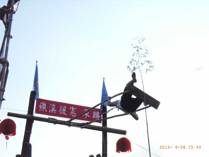 圖7：選手盪上與鈴竿相當高度時，伸腳踢鈴鐺。（本圖為當日下午之預賽。決賽係於晚上舉行，有燈光照明）（102.9.28）