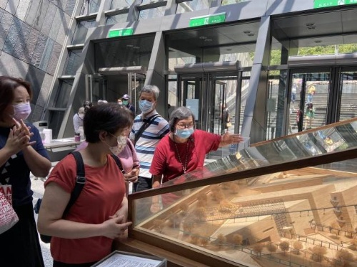 在大廳為遊客細心解說蘭博的建築模型。