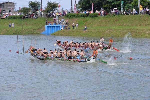 圖10：淇武蘭、洲仔尾兩船於傳統競渡中施展「壓尾背」之船技，濺起水花助行。（102.6.12. 李正煜 攝）