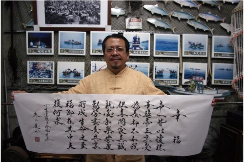 書法家廖大慶與其作品「幸福」。