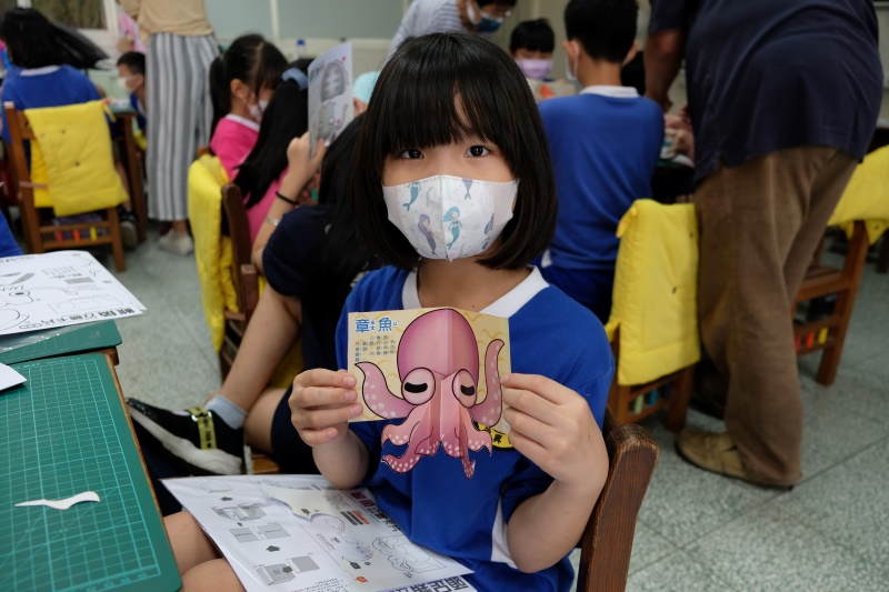 國小小朋友手持自己製作完成的粉紅色章魚立體卡片(點擊放大)